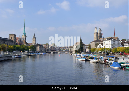 Imbarcazioni da diporto ormeggiato sul fiume Limmat a Zurigo con le guglie gemelle su Grossmünster in background. Foto Stock