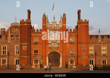 Un padre fotografie di suo figlio di fronte all'ingresso principale dell'Hampton Court Palace, Surrey, Regno Unito su una bella sera d'estate. Foto Stock