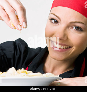 Lo chef femmina la farcitura di prodotti alimentari Foto Stock