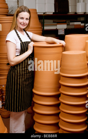 Donna che mantiene un urna decorativo in serra Foto Stock