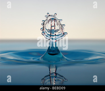 Gocce d'acqua collidere al di sopra di una superficie Foto Stock