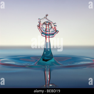 Gocce d'acqua collidere al di sopra di una superficie Foto Stock