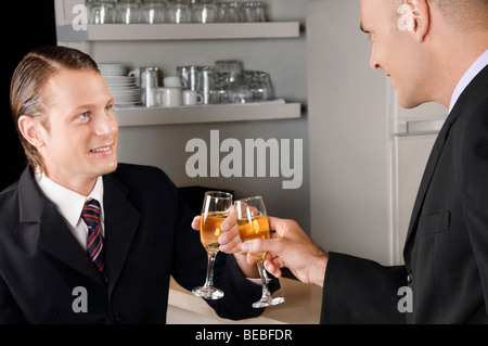 Due imprenditori tostare con il vino in un bar Foto Stock