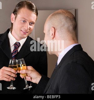 Imprenditori tostare con il vino in un bar Foto Stock