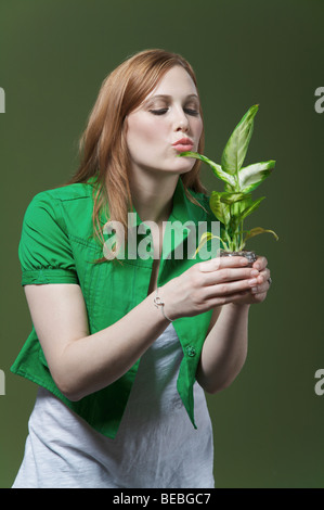 Donna baciare una piantina Foto Stock