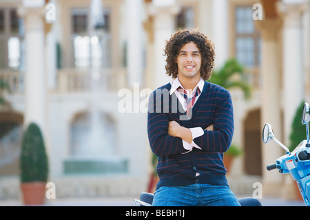 Uomo seduto su un ciclomotore con le braccia incrociate, Biltmore Hotel Coral Gables, Florida, Stati Uniti d'America Foto Stock