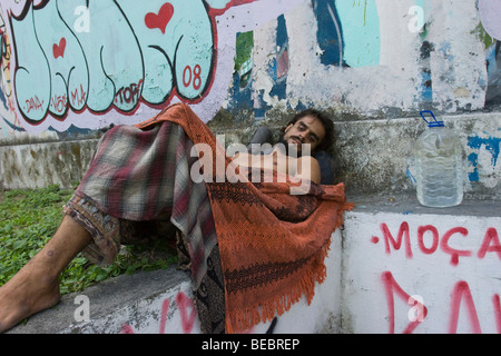 Un senzatetto uomo dorme davanti a un edificio vacante in Amazzonia città di Manaus, Brasile. Foto Stock