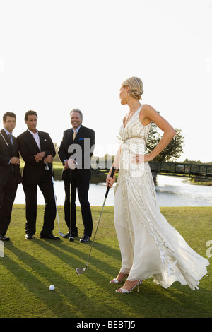 Sposa giocando a golf e tre uomini osservando il suo, Biltmore Golf, Coral Gables, Florida, Stati Uniti d'America Foto Stock