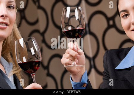 Imprenditrice bere il vino e sorridente Foto Stock