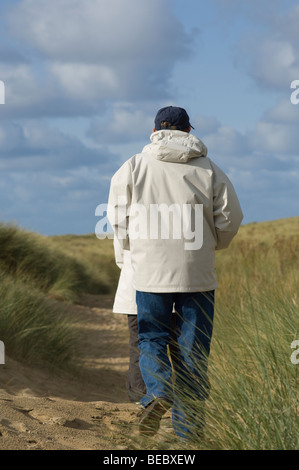 L uomo e la donna a piedi attraverso le dune di sabbia Foto Stock