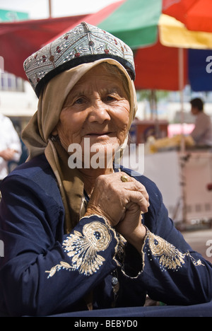 Donna locale di cappelli di vendita in un mercato di Kashgar, provincia dello Xinjiang, Cina 2008. Foto Stock