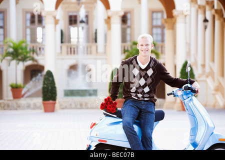 Uomo seduto su un ciclomotore e sorridente, Biltmore Hotel Coral Gables, Florida, Stati Uniti d'America Foto Stock