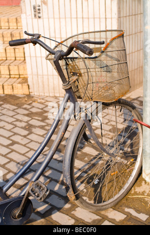 Vecchia bicicletta parcheggiata in una strada di Shanghai, Cina e Asia Foto Stock