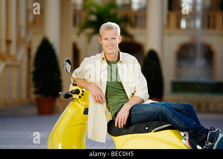 Uomo seduto su un ciclomotore e sorridente, Biltmore Hotel Coral Gables, Florida, Stati Uniti d'America Foto Stock