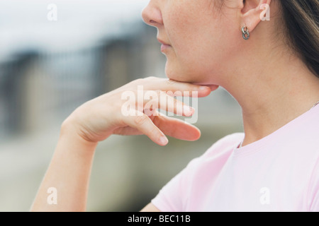 Close-up di una giovane donna di pensare con la sua mano sulla mento Foto Stock
