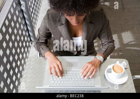 Guardando verso il basso in corrispondenza di una giovane donna che utilizza un computer portatile Foto Stock