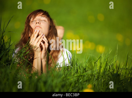 Giovane donna sdraiata sull'erba. Dof poco profondo. Foto Stock
