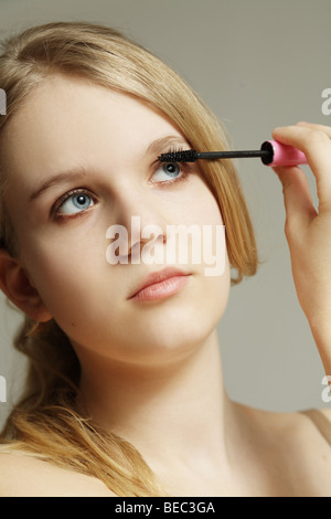 Ragazza adolescente applicazione di mascara sulle ciglia. Foto Stock