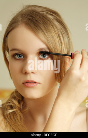 Ragazza adolescente applicazione di mascara sulle ciglia. Foto Stock