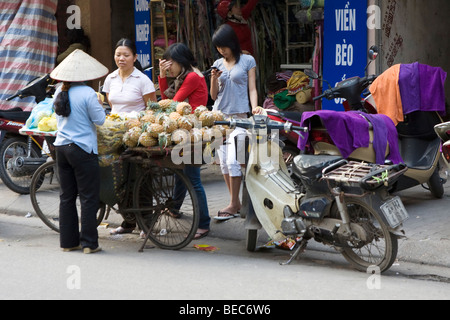 Una donna per la vendita di frutta da una bicicletta in Vietnam a Hanoi Foto Stock