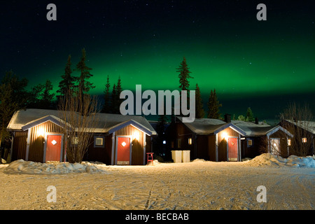 Luci del nord su cabine presso l'hotel di ghiaccio di Jukkasjärvi, Svezia. Foto Stock