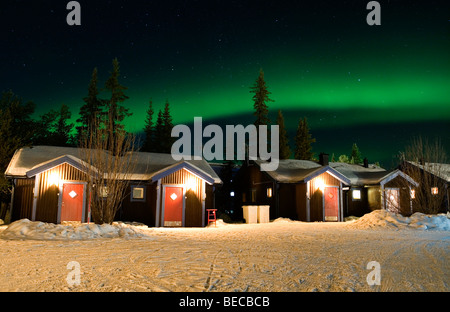 Luci del nord su cabine presso l'hotel di ghiaccio di Jukkasjärvi, Svezia. Foto Stock