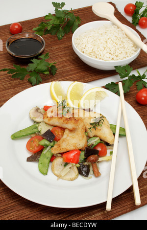 Pangasius filet su un letto di verdure asiatica dolce con salsa di soia e riso Foto Stock