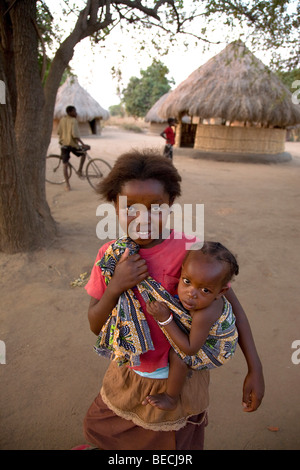 Bambino che porta un neonato in un panno, Kawaza village, Provincia Orientale, la Repubblica di Zambia e Africa Foto Stock