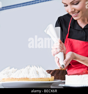 Lo chef femmina ciliegina di una torta Foto Stock
