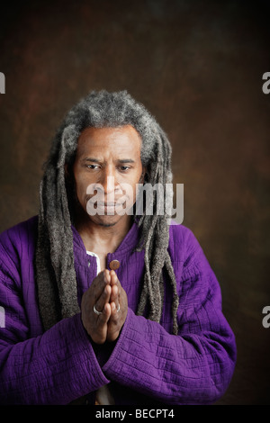 L'uomo africano con dreadlocks pregando Foto Stock