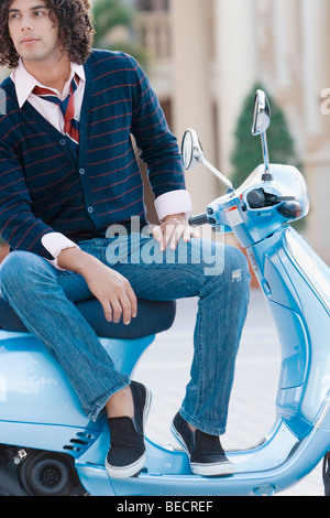 Uomo seduto su un ciclomotore e pensare, Biltmore Hotel Coral Gables, Florida, Stati Uniti d'America Foto Stock