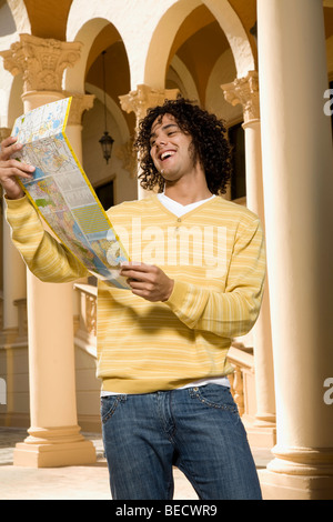 L'uomo la lettura di una mappa e sorridente, Biltmore Hotel Coral Gables, Florida, Stati Uniti d'America Foto Stock