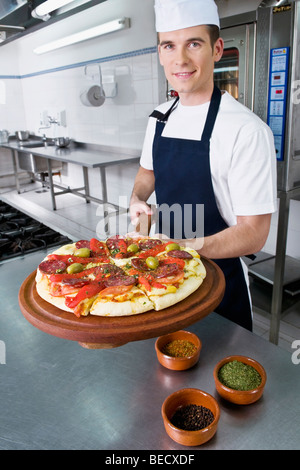 Lo chef prepara la pizza in cucina Foto Stock