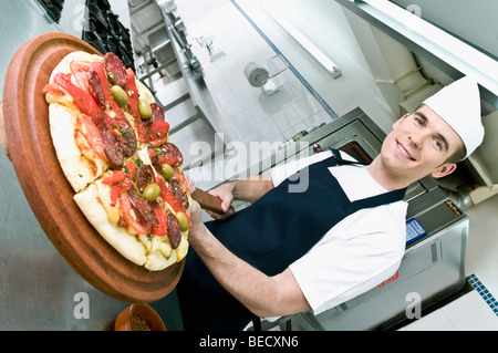 Lo chef prepara la pizza in cucina Foto Stock