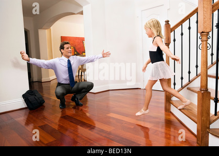 Imprenditore riceve un caloroso benvenuto da sua figlia Foto Stock
