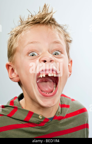 Ritratto di un 7-anno-vecchio ragazzo con un dente divario tirando una faccia Foto Stock