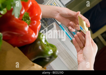 Il cliente effettuando il pagamento tramite carta di credito alla cassa Foto Stock