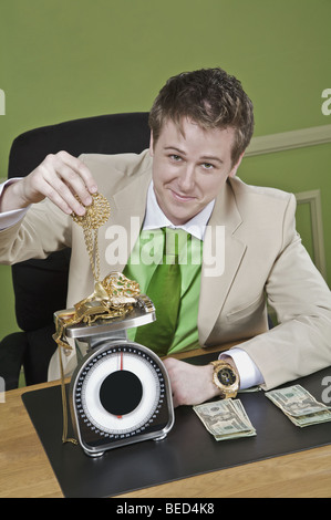 Imprenditore del peso di gioielleria in oro Foto Stock