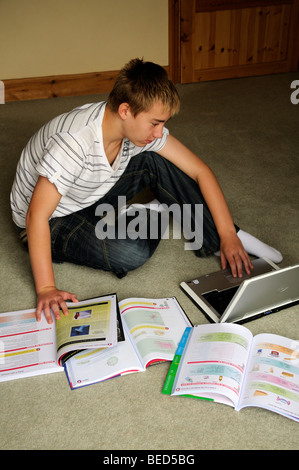 Ragazzo adolescente di revisione per gli esami GCSE studente studiare a casa Foto Stock