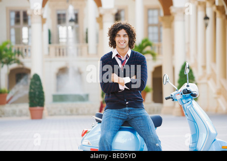 Uomo seduto su un ciclomotore con il suo braccio incrociati, Biltmore Hotel Coral Gables, Florida, Stati Uniti d'America Foto Stock