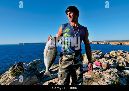 Il Portogallo, Algarve: Giovane pescatore con pesci pescati dal westcoast Foto Stock