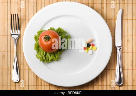 La droga sulla piastra che illustra la scelta tra medicina e mangiare sano Foto Stock