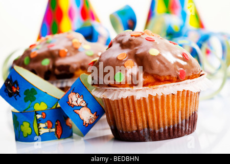 Muffin e carta streamers, immagine simbolica di carnevale o di compleanno di bambini Foto Stock