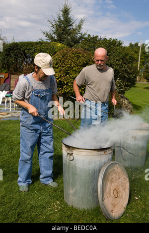 Rimozione di pentole da ossidazione di barili durante il processo Raku, STATI UNITI D'AMERICA Foto Stock