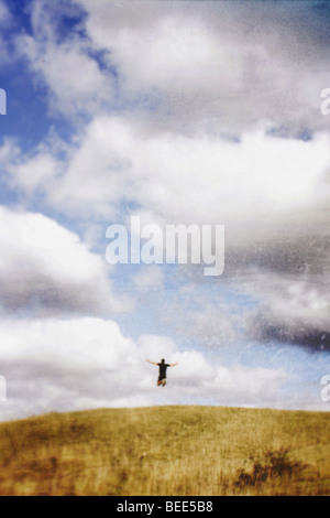 L'uomo salti di gioia su una collina Foto Stock