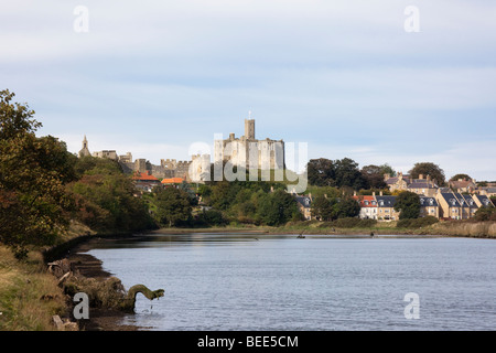 Warkworth, Northumberland, England, Regno Unito, Europa. Vista lungo il fiume Coquet a Warkworth rovine del castello sopra il villaggio Foto Stock