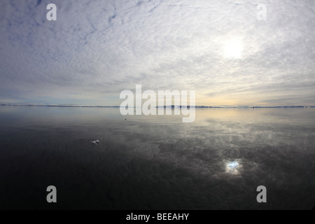 La calma iceless Oceano artico riflette il cielo al largo delle isole Svalbard. Foto Stock