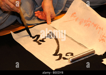 Un calligrafo disegno caratteri coreani, Corea Foto Stock