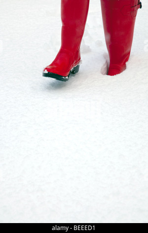 Una coppia di rosso gli stivali da pioggia nella neve abbondante spazio di copia Foto Stock