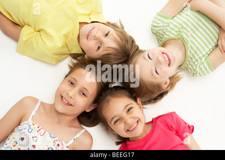 Cerchio di quattro giovani amici sdraiato sorridente Foto Stock